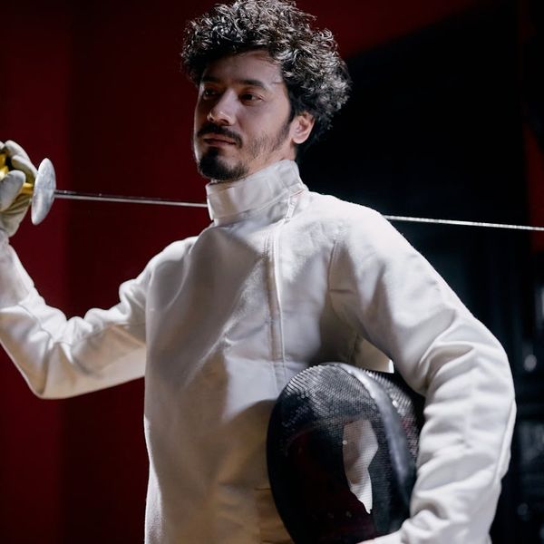 Focused man holding a stability pose, showing strength and concentration.